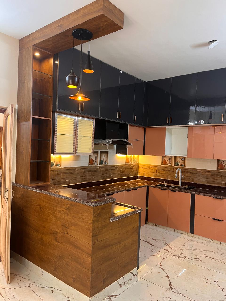 U-shaped modular kitchen with wooden breakfast counter and pendant lighting
