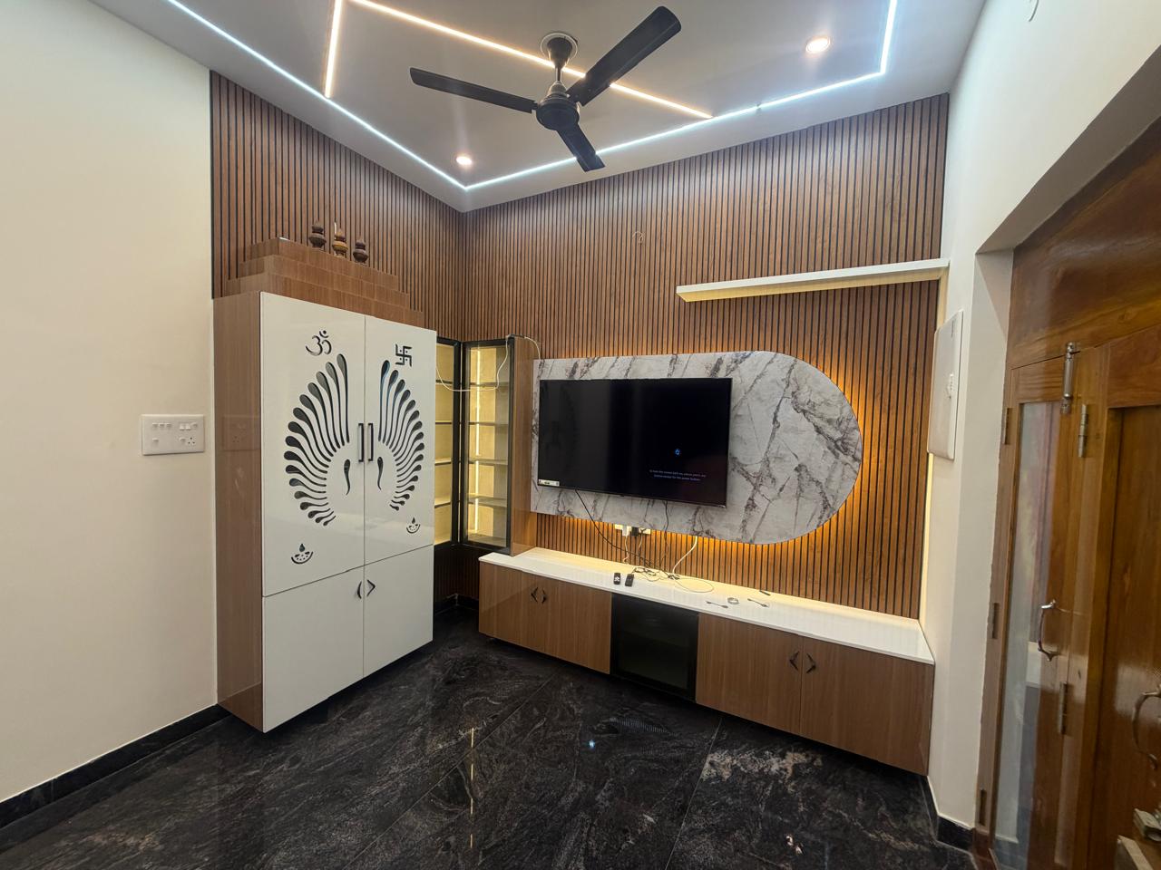 Media wall with wooden slat paneling, marble TV backdrop and cove lighting